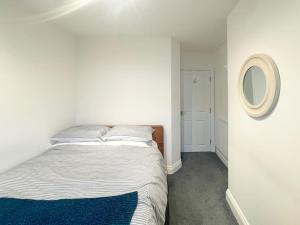 a white bedroom with a bed and a mirror at Cosy & Comfortable - Heart of Hove - Beach Getaway in Brighton & Hove