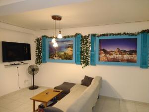 sala de estar con sofá y 2 cuadros en la pared en Periklis House en Ixia