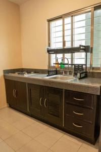 a kitchen counter with a sink and a window at acogedora casa con hospedaje para 2 personas in Chetumal