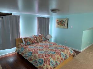 um quarto com uma cama com um edredão colorido em Northside Cape em Richmond