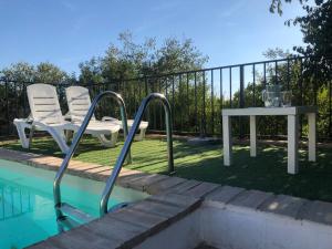 a pair of chairs and a table next to a pool at Casa del Almezo in Almodóvar del Río