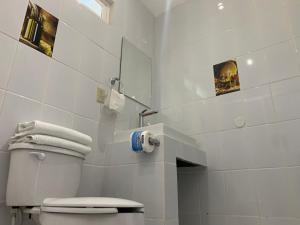 a white bathroom with a toilet and a mirror at Posada Del Valle in Valle de Guadalupe +2 photos