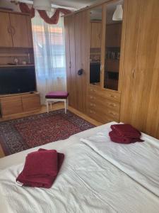 een slaapkamer met een bed met twee rode handdoeken erop bij Ferienwohnung Korneuburg bei Wien in Korneuburg