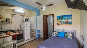 Una pequeña cocina con una cama en una habitación en Casatemporadaperó, en Cabo Frío