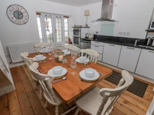 a kitchen with a wooden table and chairs in a kitchen at Rock House in Narberth