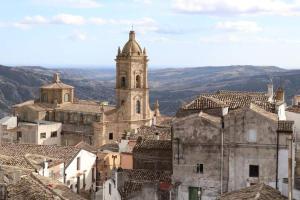 an old building with a clock tower in a city at La casetta in Pomarico