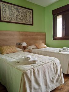 2 camas en una habitación con paredes verdes en Casa Rural Buenavista, en Mogarraz