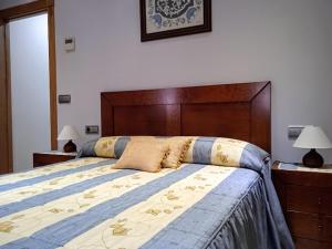 Schlafzimmer mit einem großen Bett mit einem Kopfteil aus Holz in der Unterkunft Casa Rural Buenavista in Mogarraz