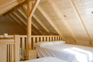 Habitación con cama en un ático de madera en Càmping Els Roures, en Camprodon