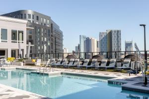 a swimming pool with lounge chairs and a city skyline at Locale The Gulch - Nashville in Nashville