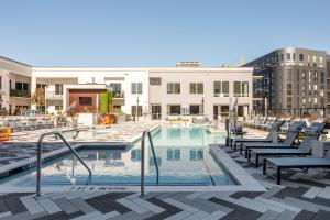 uma piscina com cadeiras e um edifício em Locale The Gulch - Nashville em Nashville