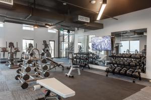 a gym with lots of tread machines and a flat screen tv at Locale The Gulch - Nashville in Nashville
