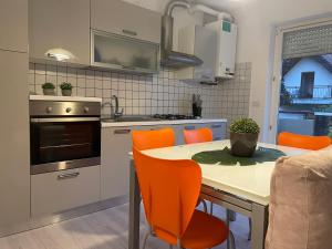 uma cozinha com uma mesa de jantar e cadeiras laranja em Diamond House em Mattarello