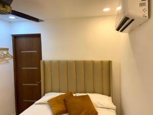 a bedroom with a bed with two pillows on it at Studios Don Bosco in Santo Domingo