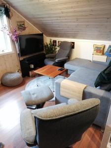 sala de estar con sofá, sillas y TV en Ro - Utsikt-Toppturer, en Kleppstad