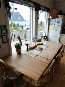 una mesa de madera en una cocina con una gran ventana en Ro - Utsikt-Toppturer, en Kleppstad