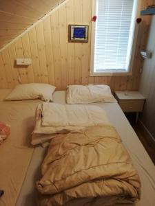 2 camas en una habitación con paredes de madera en Ro - Utsikt-Toppturer, en Kleppstad