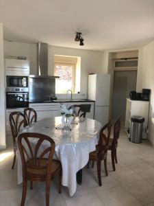 a kitchen with a table with chairs and a white table cloth at Résidence Merlin Appartement Arthur in Saint-Malon-sur-Mel