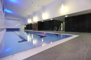 a large swimming pool with blue water in a building at Clayton Hotel Galway in Galway
