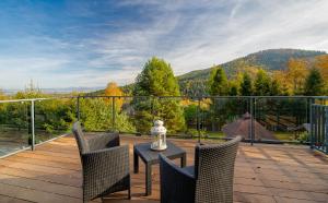 patio con mesa y sillas en el balcón en Loft Apart View & Wellness, en Szczyrk