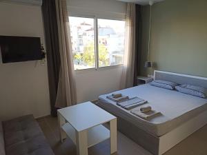 een slaapkamer met een bed met een tafel en een raam bij Kilkis Central Studio in Kilkís