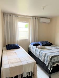 1 dormitorio con 2 camas y ventana en Sol de Bora Bora, en Salvador