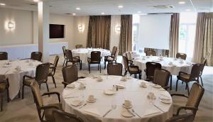 a conference room with white tables and chairs at Holiday Inn Kenilworth - Warwick, an IHG Hotel in Kenilworth