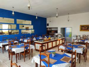 ein Restaurant mit blauen Wänden und Holztischen und -stühlen in der Unterkunft Hotel Itarare in Itararé