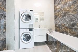 un bagno con lavatrice e asciugatrice accanto a un lavandino di Varsovia Residence apartament 17 Parking a Elblag