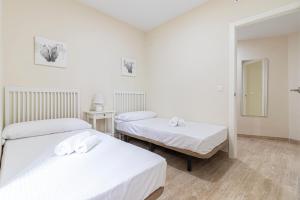 sypialnia z dwoma łóżkami i lustrem w obiekcie Allo Apartments Consistorio Centro 2 Habitaciones w mieście Jerez de la Frontera