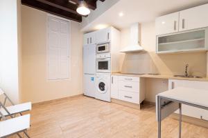 cocina con armarios blancos, mesa y fregadero en Allo Apartments Consistorio Centro 2 Habitaciones, en Jerez de la Frontera