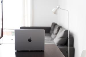 un ordenador portátil de manzana sentado en una mesa en una sala de estar en Apartamento Avilés, en Ronda