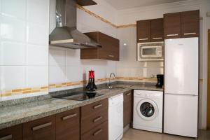 cocina con nevera blanca y lavavajillas en Apartamento Avilés, en Ronda