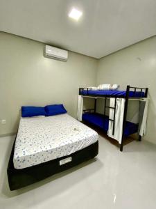 een slaapkamer met een bed en een stapelbed. bij Hostel Flor de Carajás in Parauapebas