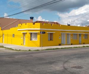 佩洛塔斯Pousada Casa Valério的街边的一栋黄色建筑