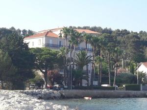 Appartement Villa Tamaris, vue mer في لا سين سور مير: بيت أبيض كبير على تلة بجوار الماء