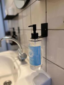 a bottle of soap sitting on top of a bathroom sink at Buer City Apartment mit Balkon in Gelsenkirchen +37 photos