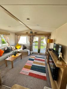 a living room with a couch and a tv at Newquay Bay Resort - Summer Days 135 in Porth