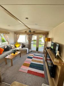 un soggiorno con un divano e una TV di Newquay Bay Resort - Summer Days 135 a Newquay Bay Resort