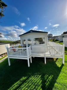 un cenador blanco sentado en la hierba en Newquay Bay Resort - Summer Days 135 en Newquay Bay Resort