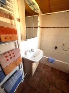 a bathroom with a sink and a tub at Ferienhaus Serafina in Rieden am Forggensee