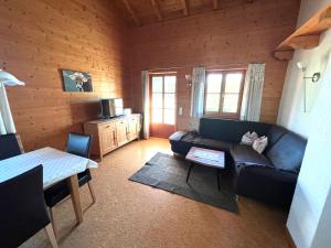 a living room with a couch and a table at Ferienhaus Serafina in Rieden am Forggensee