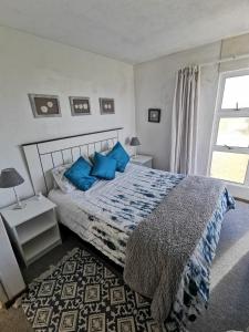- une chambre avec un lit doté d'oreillers bleus et d'une fenêtre dans l'établissement Paradise@Pearly, à Pearly Beach