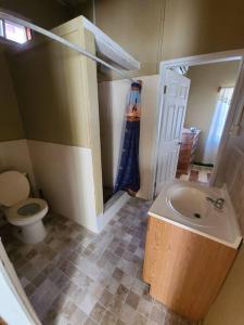 a bathroom with a sink and a toilet at Cozy 2 bedroom beachfront cabin in Canouan