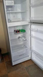 an open refrigerator with its door open and its contents at Cozy 2 bedroom beachfront cabin in Canouan