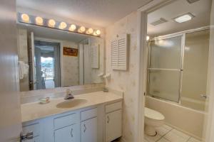a bathroom with a sink and a toilet and a mirror at El Matador 235 - Beautiful views of the courtyard and Gulf of Mexico in Fort Walton Beach +22 photos