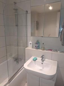 a white bathroom with a sink and a shower at Flat near City Centre Liverpool 10 mins to Arena in Liverpool