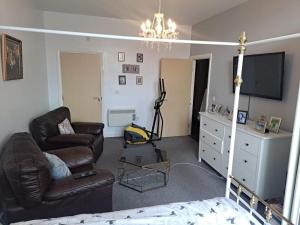 a living room with a couch and a tv at Flat near City Centre Liverpool 10 mins to Arena in Liverpool