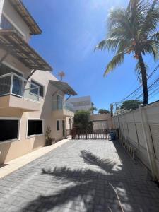 a house with a palm tree and a driveway at Sol de Bora Bora in Salvador