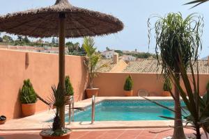 uma piscina com um guarda-sol e algumas plantas em La Barossa em Algeciras